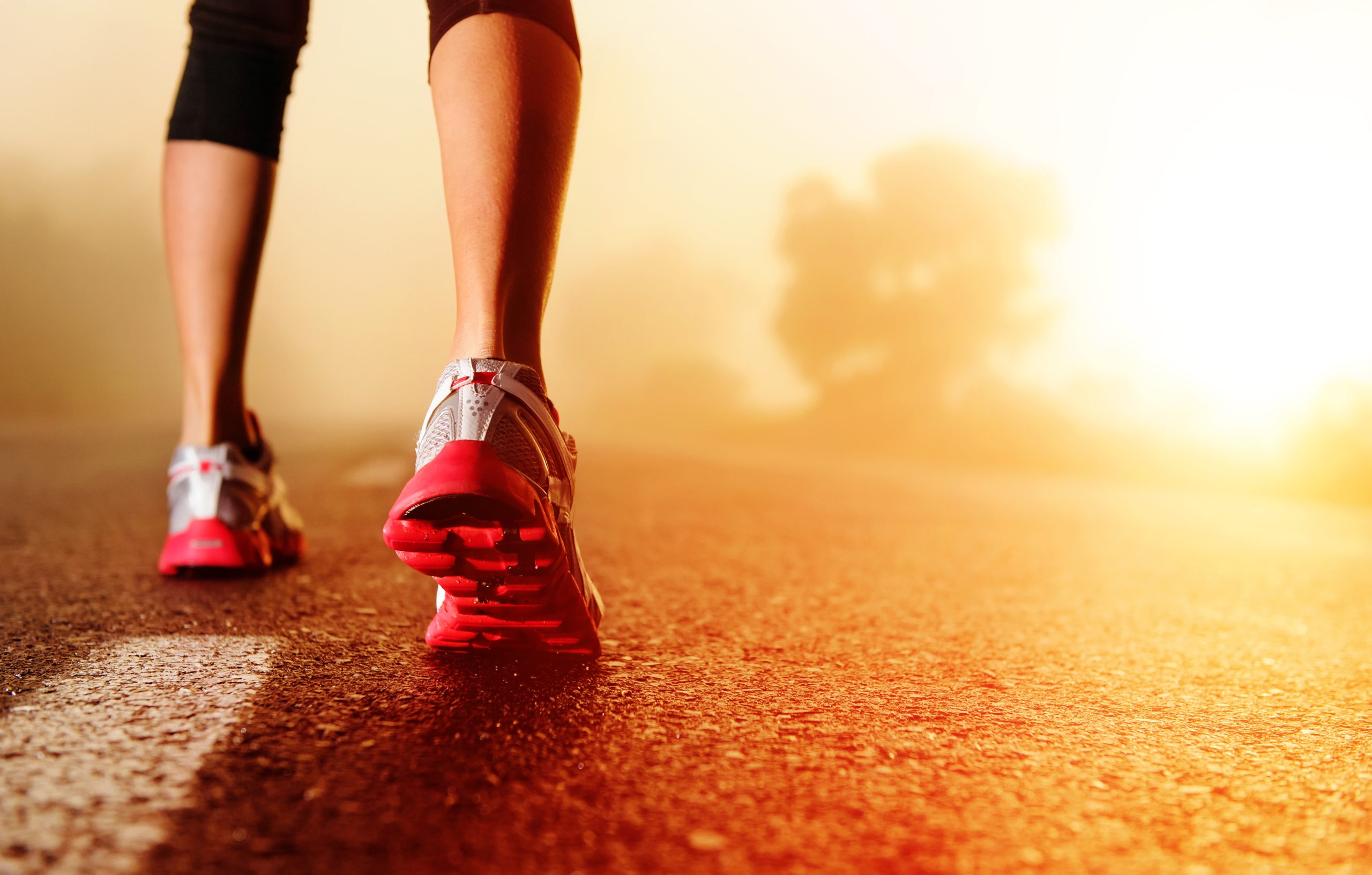 Running shoes on a sunlit road