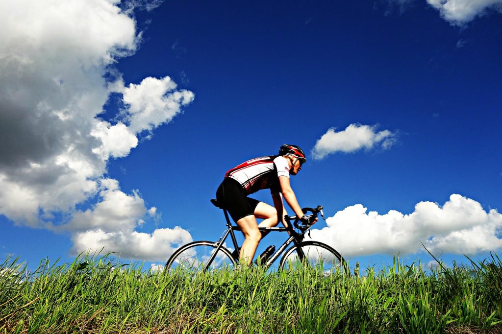 Road cyclist viewed from below against a blue sky