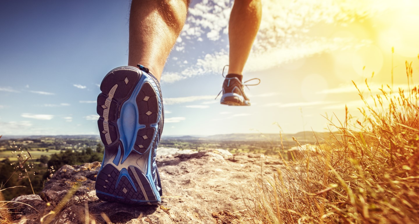 Runner taking the next step on a sunlit trail